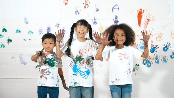 istock Diverse students put hands up together show colorful stained hands. Erudition. 2099871014