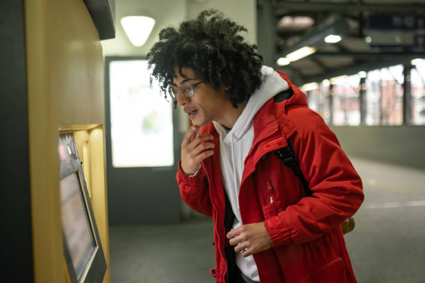 istock Curly-haired guy standing near ATM and looking at it 2099886268