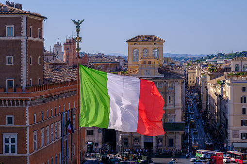 Rome, IT - 28 July 2023:  Italian flag waving in the wind at Piazza Venezia