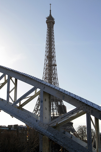 Eiffel Tower close up, famous Paris French capital monument of steel in the city centre, tourist attraction and the most visited landmark against the blue sky in sunlight, sun beams