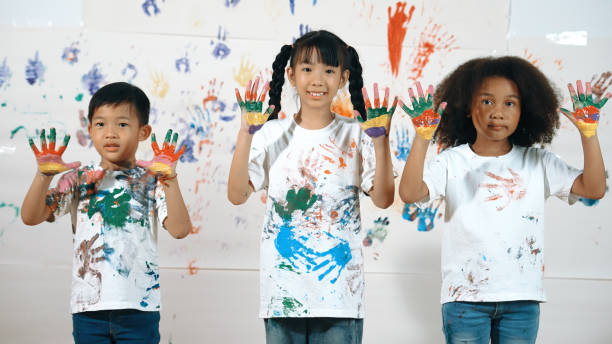 istock Diverse students put hands up together show colorful stained hands. Erudition. 2099946713
