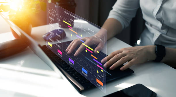 istock Project manager working on laptop and updating tasks and milestones progress planning with Gantt chart scheduling interface for company on virtual screen. Business Project Management System. 2099989416