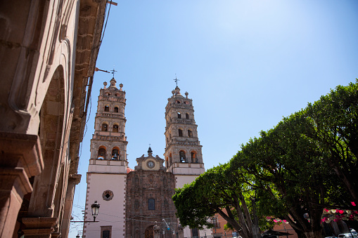 The twin bell towers of the Nuestra Señora de la Luz parish church, seen across the central garden in the historic center of the town of Salvatierra in the state of Guanajuato