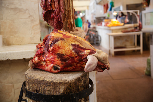 A cow head with it's tongue sticking out resting on a block at the central market in the town of Salvatierra in the state of Guanajuato