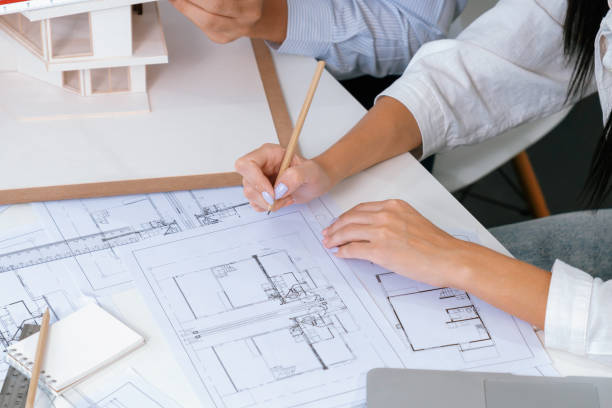 istock Closeup of engineer team working together to measure house model. Immaculate. 2100032444