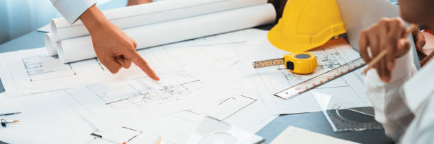 istock Engineer partner drawing and working on blueprint design together. Insight 2100040879