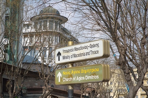 a photo of street signs with the names of the streets written both in english and greek language,in a town in greece thessaloniki