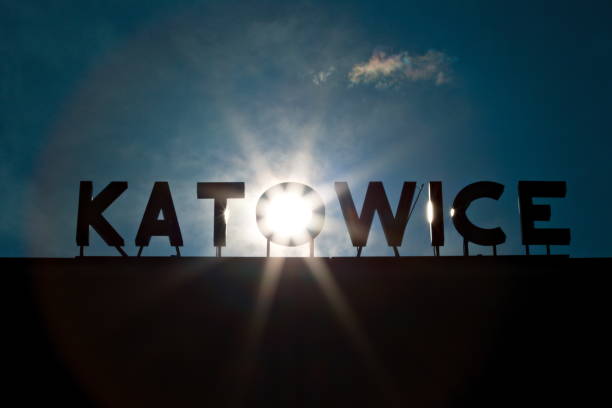 The photo of a Katowice, Poland train station neon sign backlit by the sun, precisely positioned behind and shining through the middle letter \
