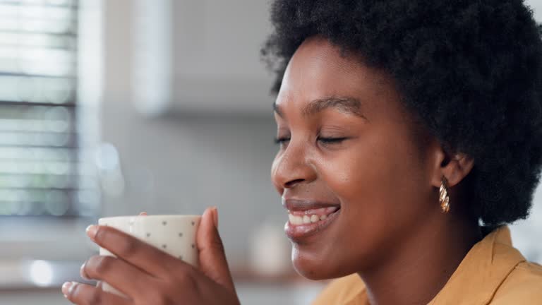 Portrait of satisfied woman drinking tea on kitchen.