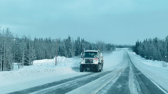 A snow plow clearing the roadway in Alaska in Winter