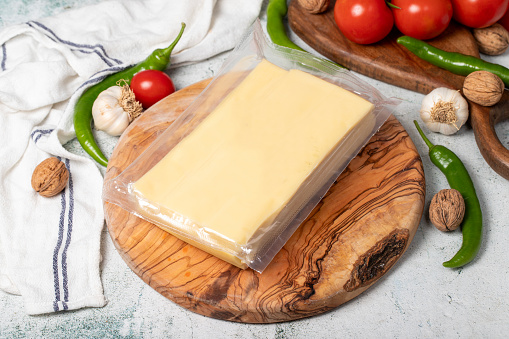 Packaged cheese. Kashar cheese or kashkaval cheese on a wood serving board. local name kasar peyniri