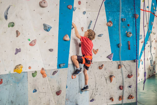 istock Boy at the climbing wall without a helmet, danger at the climbing wall 2100146205