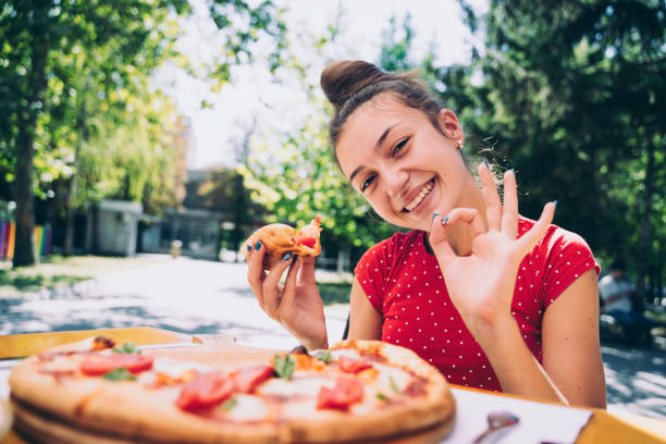 istock Teenager eating pizza 2100152987