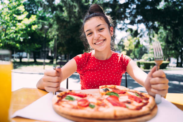istock Teenager eating pizza 2100152988