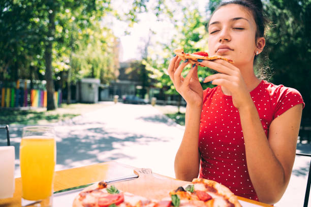 istock Teenager eating pizza 2100152990