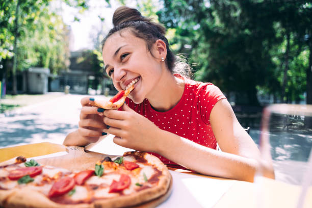 istock Teenager eating pizza 2100152993