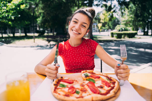 istock Teenager eating pizza 2100152994