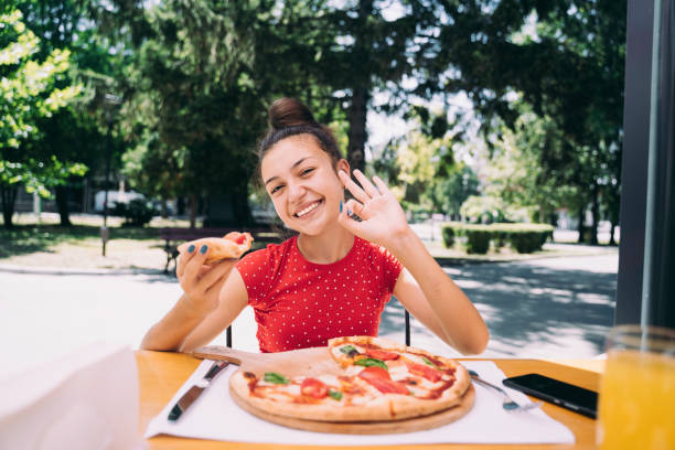 istock Teenager eating pizza 2100152996
