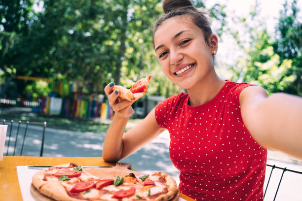 istock Teenager eating pizza 2100152997