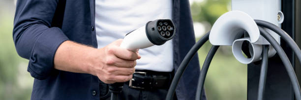 istock Man recharging battery for electric car during road trip. Exalt 2100176477
