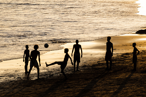 People playing soccer on the beach