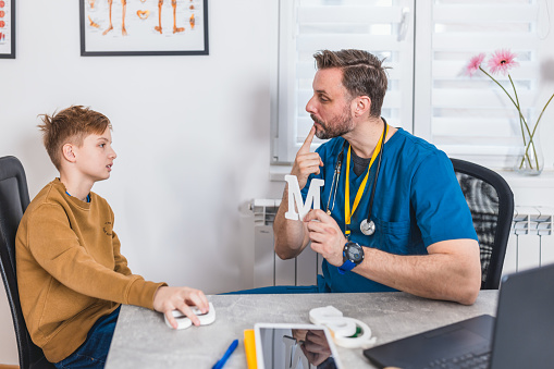 At the speech therapist's office, a boy works on building his voice and confidence, navigating through exercises designed to enhance his verbal expression