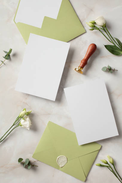 istock Blank wedding invitation cards, envelopes, flowers and wax stamp on stone table. Flat lay, top view, copy space. 2100232950