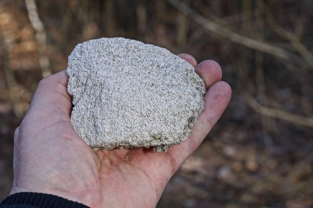 istock a man hand holds a large white piece of stone 2100233953
