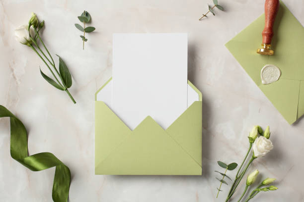 istock Olive color envelope with blank paper card inside and wedding stationery with flowers on stone background. 2100234021