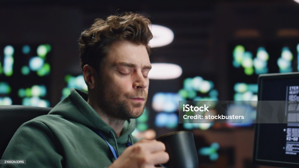 Overworked Analyst Drinking Coffee Coding At Computer Data Center ...