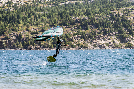 Waterton Park, Alberta, Canada â August 26, 2023: Waterton Lakes National Park - Water sports enthusiast surfing with Slick SLS Duotone equipment