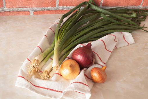 Creative arrangement with organic onion on marble kitchen table. Healthy food concept