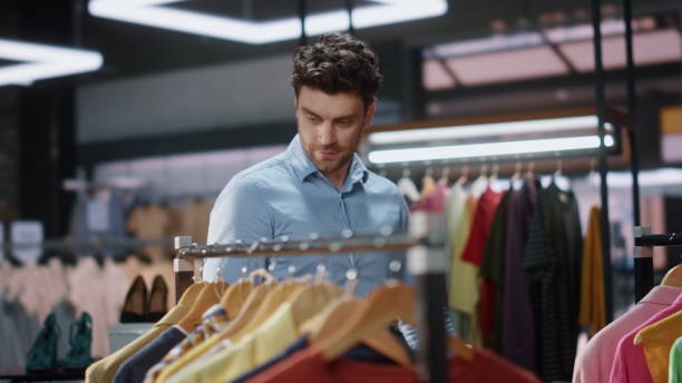 istock Man client walking clothes rows in boutique closeup. Satisfied customer smiling 2100291464