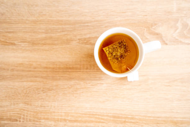 A mug of tea with teabag on wooden table, teabag, cup, sun, indoor