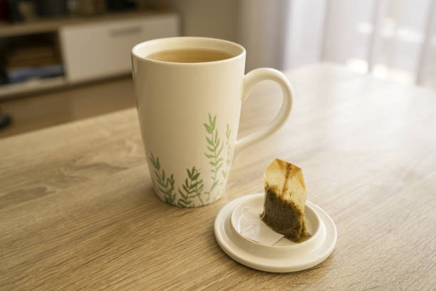 A mug of tea with teabag on wooden table, teabag, cup, sun, indoor