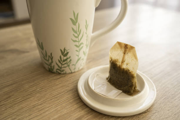 A mug of tea with teabag on wooden table, teabag, cup, sun, indoor