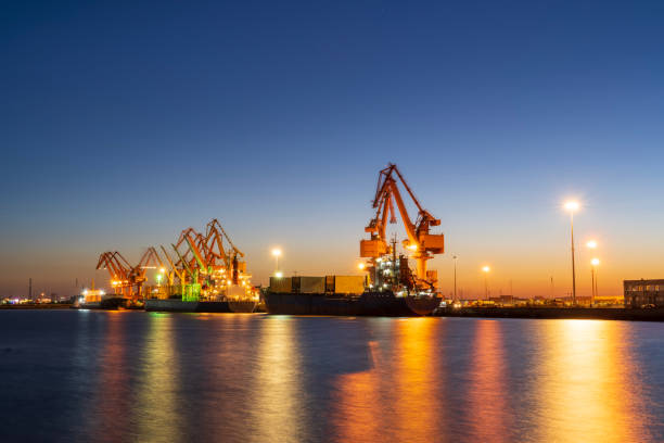 istock Gantry crane and cargo ship in the evening, Shipping and logistic concept 2100311561