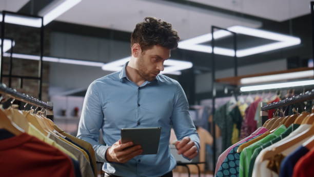 istock Shop assistant checking tablet working in store closeup. Man doing inventory 2100323508