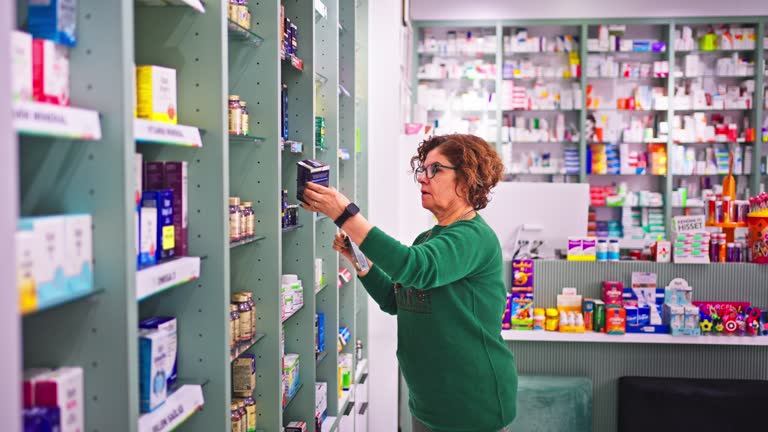 Senior woman reading the back of the medicine bottle at the pharmacy