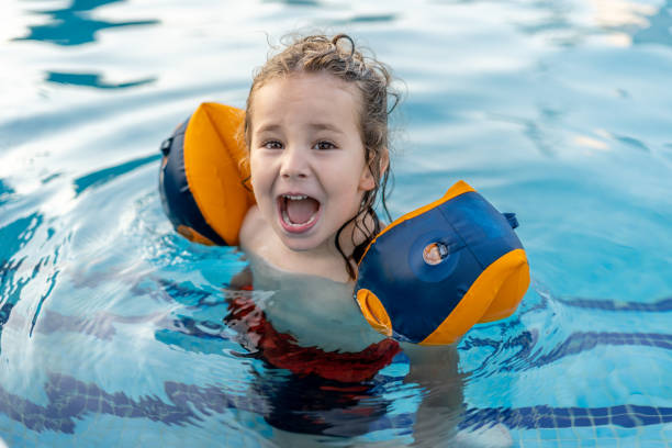 istock A young boy is in the water with a blue and orange floatie 2100384325
