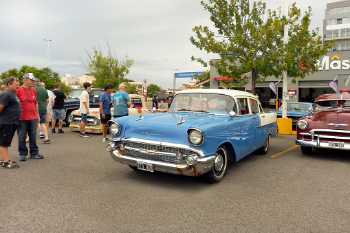 Buenos Aires, Argentina - Feb 25, 2024: Old shiny blue and white 1957 Chevrolet 150 One Fifty four door sedan at a classic car show in a parking lot. Copy space.