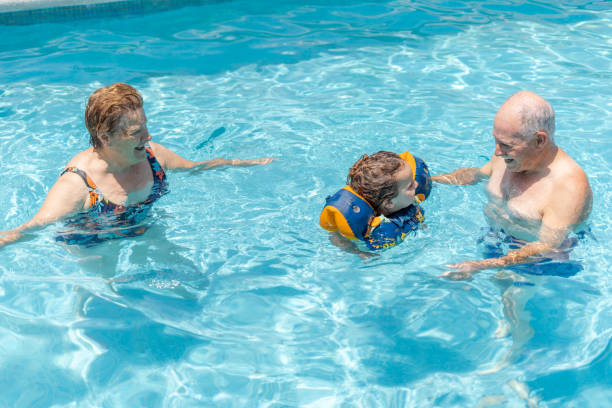 istock Elderly people playing in the water with small child 2100412939