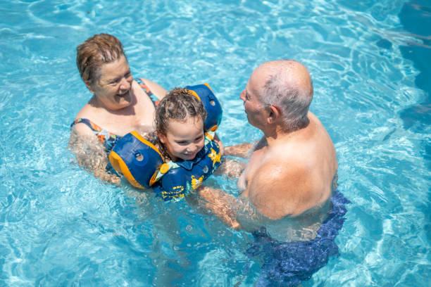 istock Elderly people playing in the water with small child 2100412945
