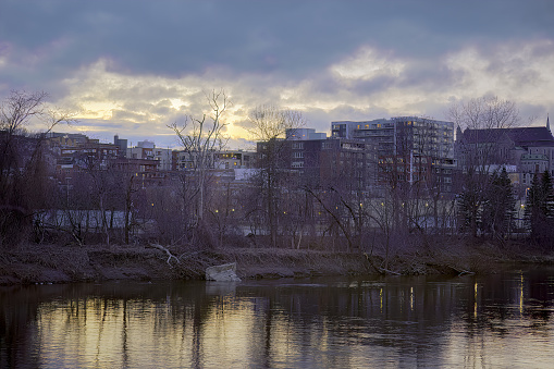 Sherbrooke downtown river view with business buildings small city in Quebec, Canada Eastern Townships Estrie sunset water leafless landscape