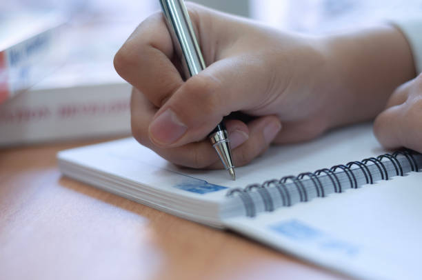 istock hands writing on a blank book in office desk 2100481077