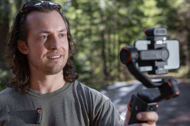istock Young man filming with a phone gimbal 2100491689