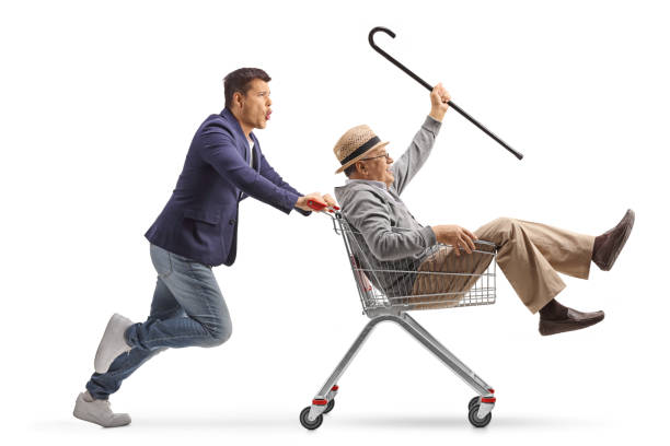 istock Man pushing a crazy elderly gentleman inside a shopping cart 2100499350