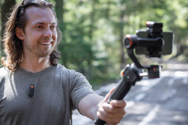 istock Young man filming with a phone gimbal 2100503580