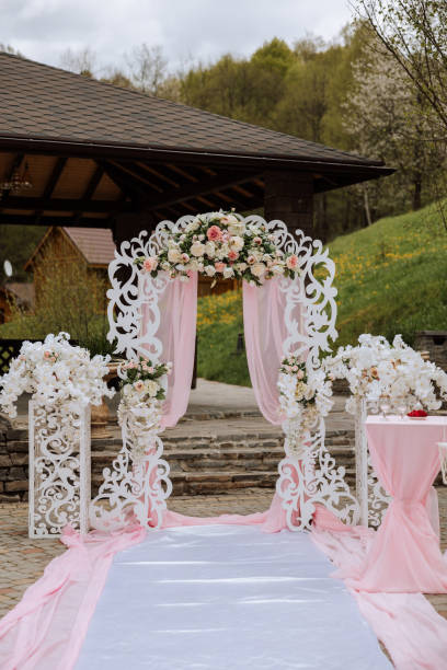 istock Wedding decor. White track. A white and pink arch decorated with flowers. Preparation for the wedding ceremony. Celebration 2100519680