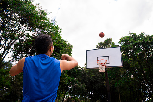Man training basketball in court in sunny day at summer